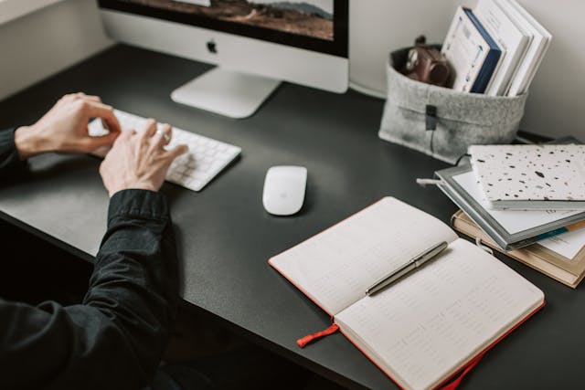 a person sitting at their desk working on their computer