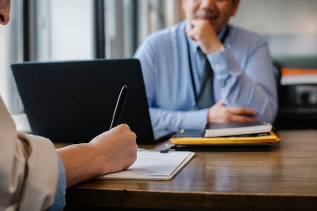 person filling out a rental application in front of a property manager