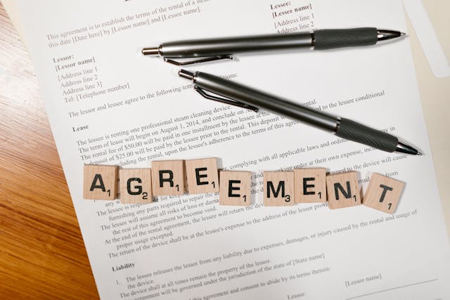 paper-with-pens-and-blocks-ontop-spelling-agreement