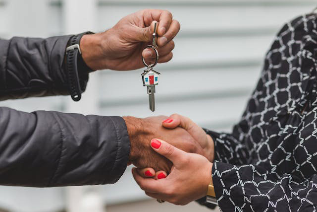 two-people-shaking-hands-and-exchanging-house-keys